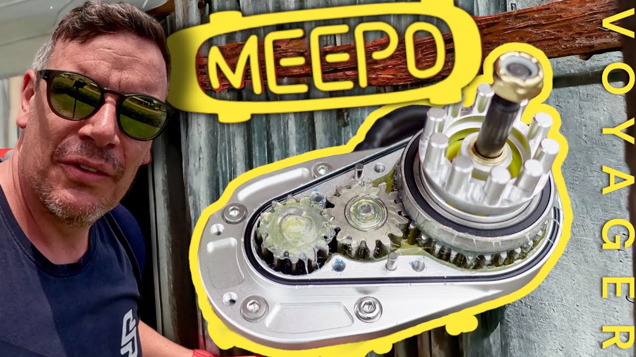 A man in sunglasses stands next to a detailed image of a Meepo Voyager electric skateboard motor.