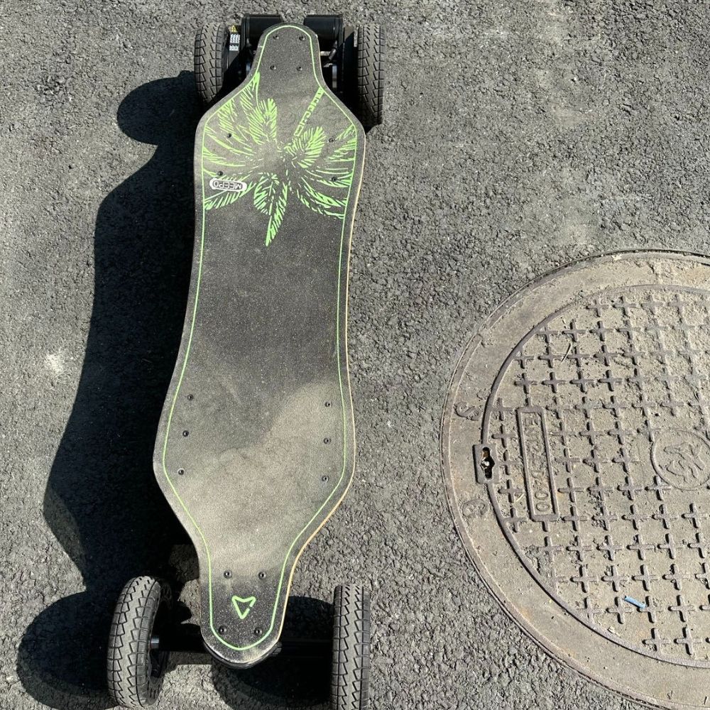 Top view of a DIY electric skateboard with a unique design and large wheels.