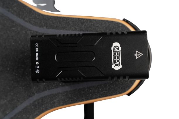 Meepo skateboard light on the top of a skateboard deck for enhanced visibility