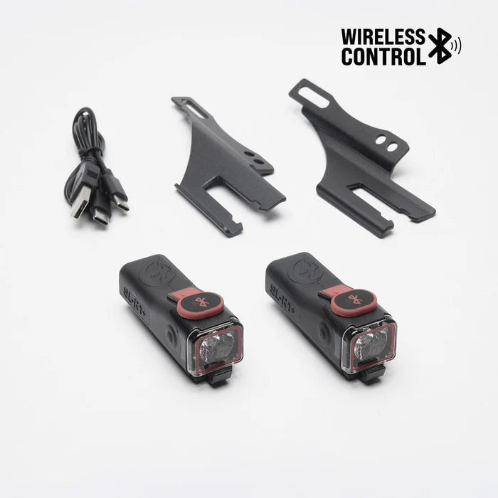 Two SL-R1+ brake lights, USB-C cable, and mounting brackets for skateboards.