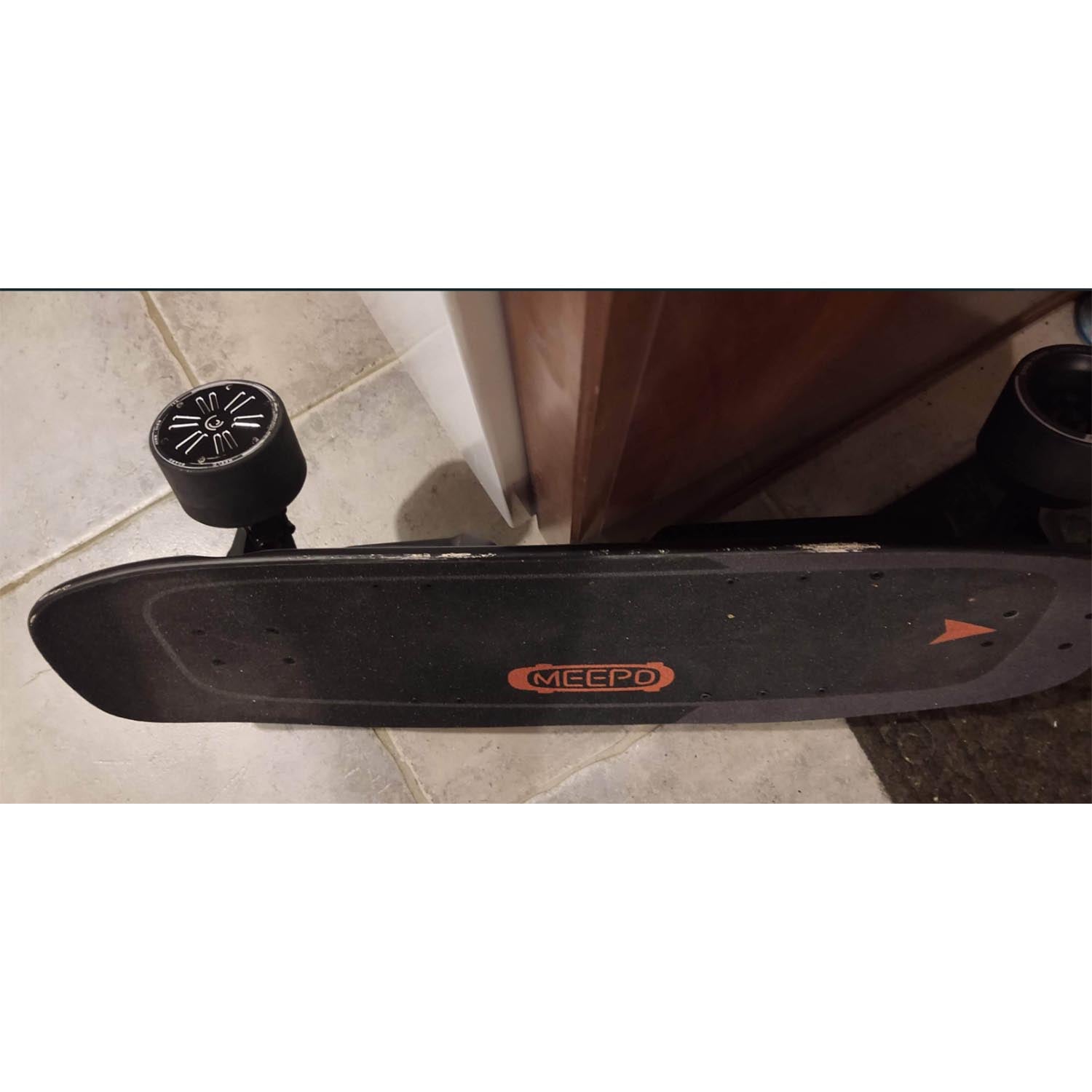 Top view of Meepo refurbished electric skateboard with black textured deck and colorful wheel.