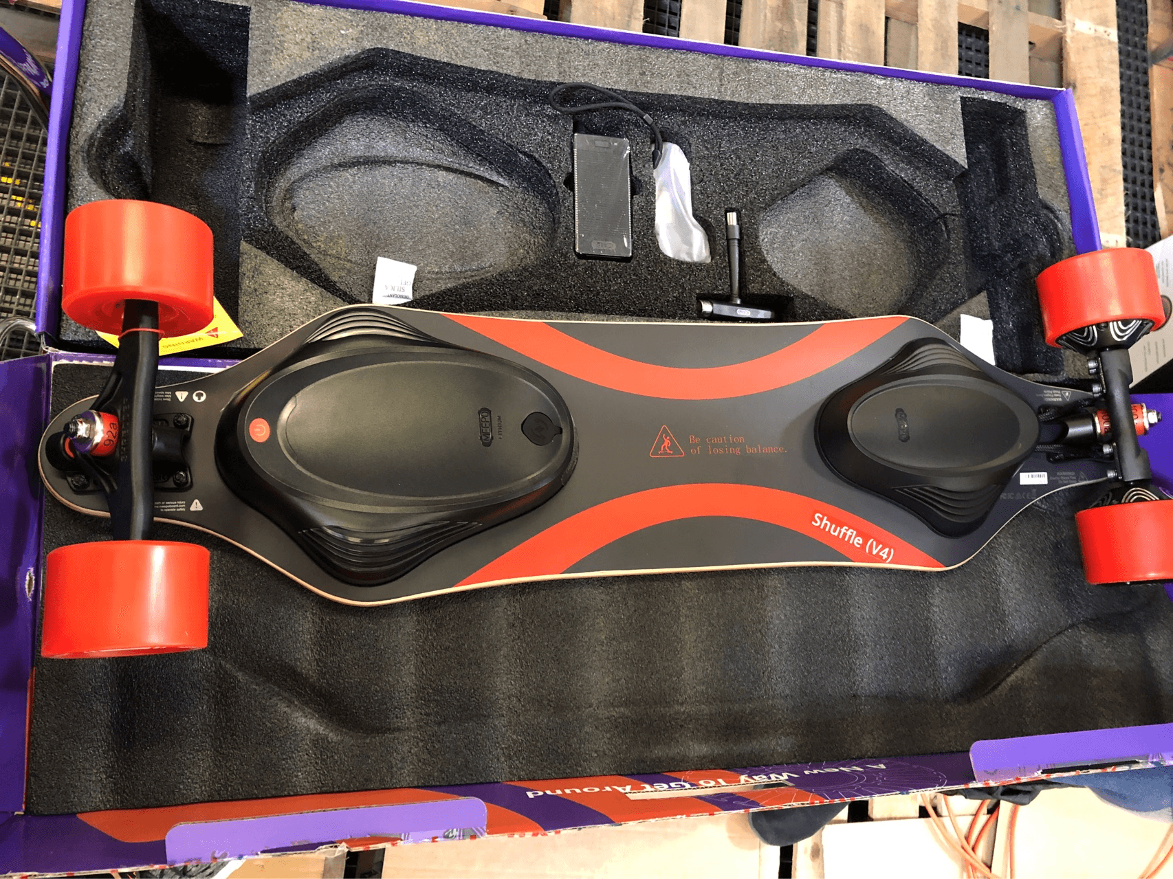 Meepo refurbished electric skateboard with sleek black body and red wheels in packaging.